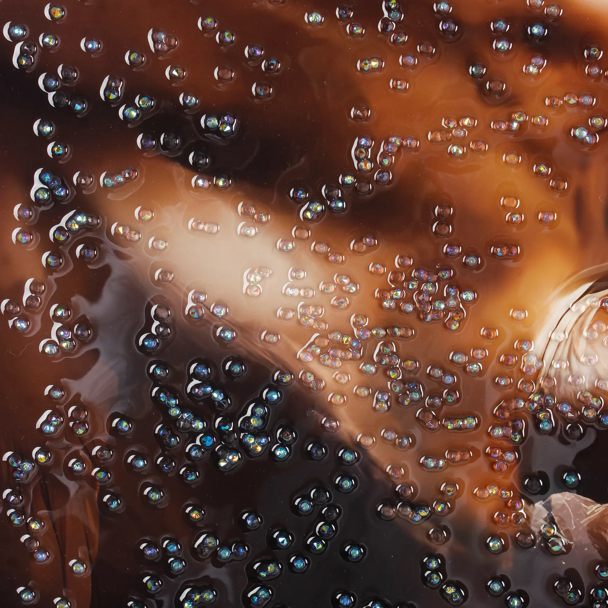Extreme close-up of the horse's brown coat covered in hundreds of iridescent faceted crystal rhinestones that shimmer with blue, purple, and gold reflections, set in a glossy clear resin base.
